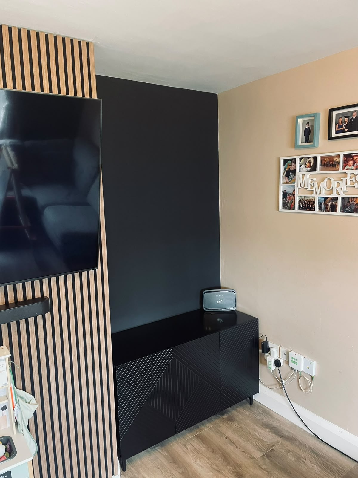 Slatted oak media wall with floating shelves and black built-in cabinet by Stonevale Construction