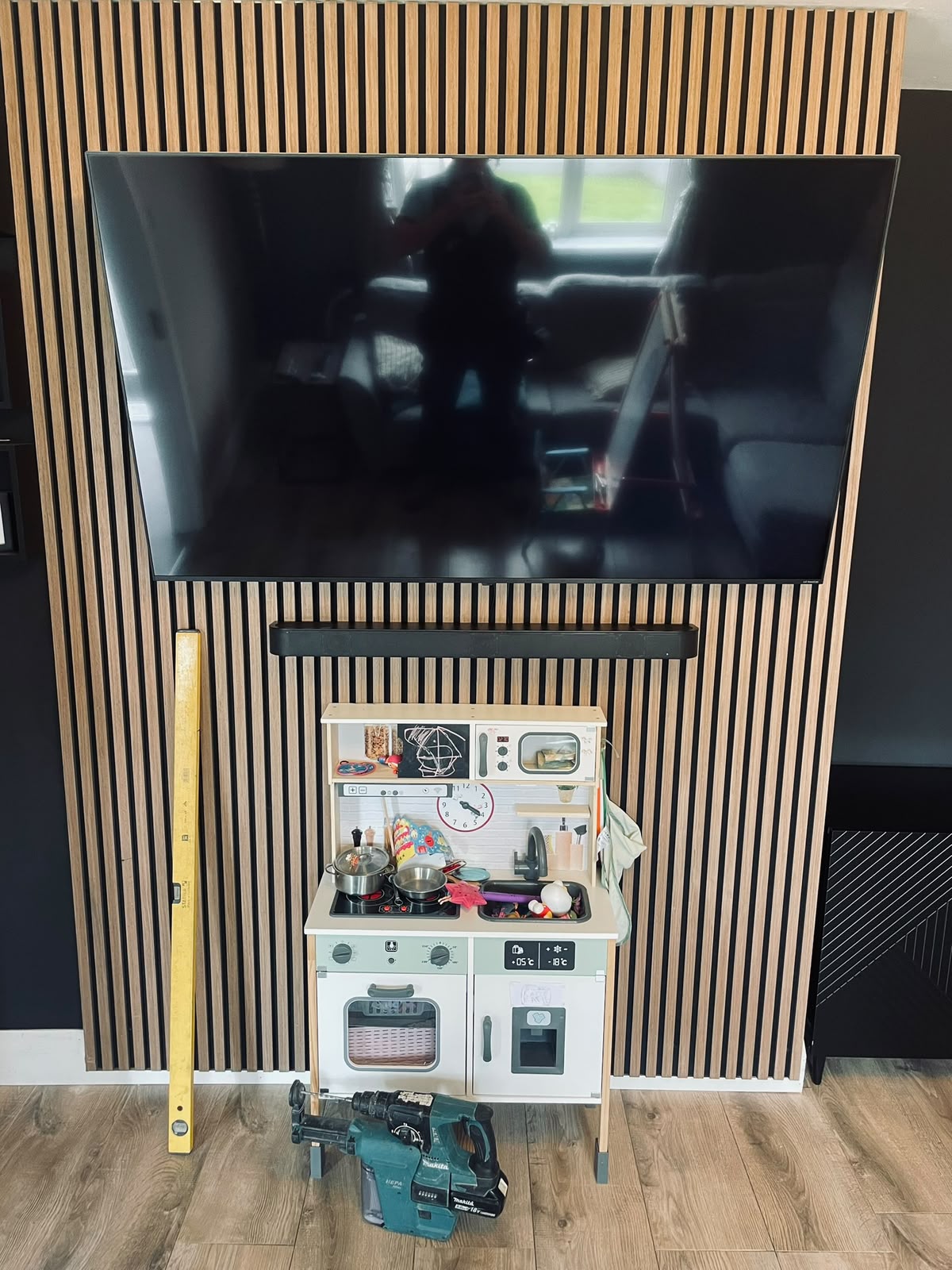 Wall-mounted TV on slatted oak panelling by Stonevale Construction