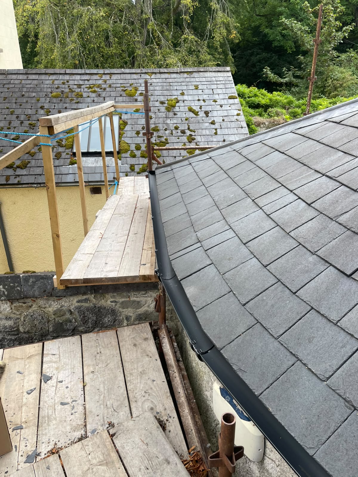 New slate roof beside old moss-covered slate roof, Stonevale Construction